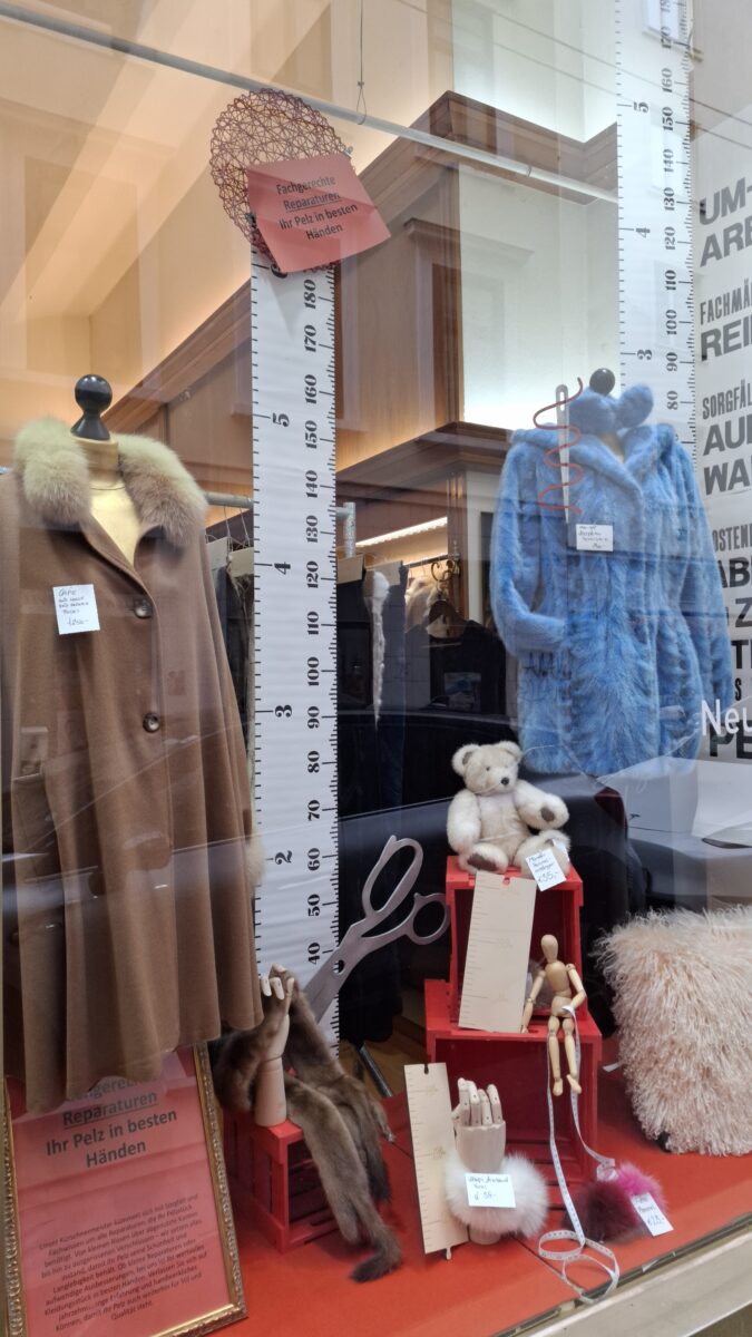 Auslage, braunes Cape mit Fuchskragen, blau gefärbte Nerzpfotenjacke mit Kapuze, 